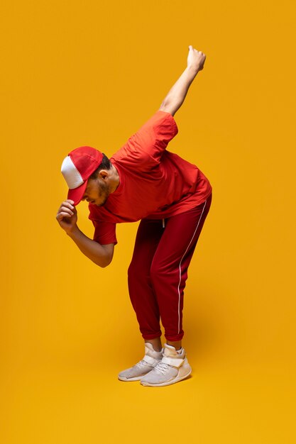 Hombre de tiro completo bailando con fondo amarillo.