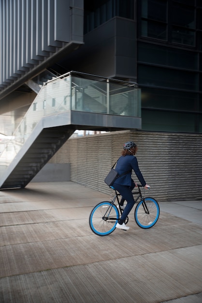 Foto gratuita hombre de tiro completo en bicicleta con casco de seguridad.