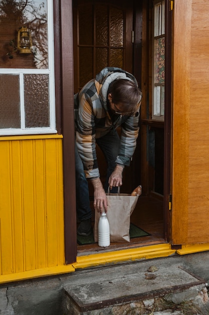 Hombre de tiro completo con bolsa de papel y botella