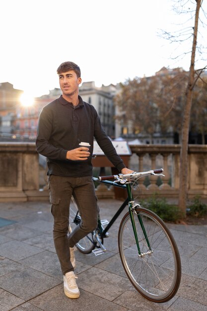 Hombre de tiro completo con café y bicicleta