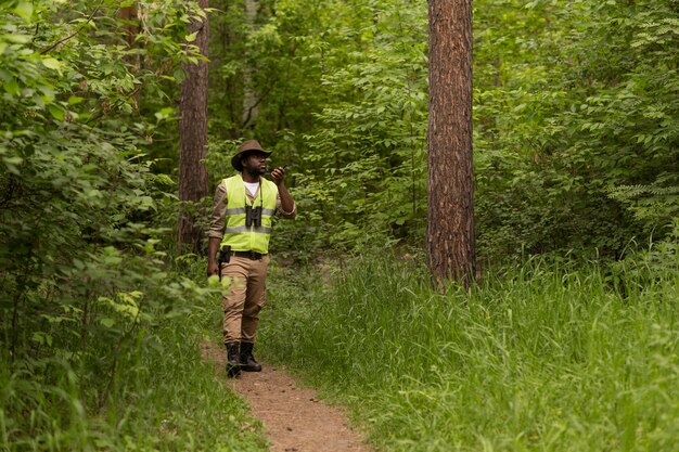 Hombre de tiro completo caminando en el bosque