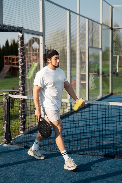 Hombre de tiro completo en la cancha de tenis