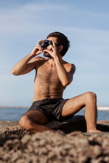 Hombre de tiro completo con cofre peludo en la playa