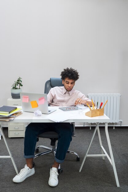 Hombre de tiro completo con computadora portátil y tableta