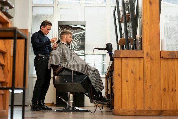 Hombre de tiro completo cortándose el pelo