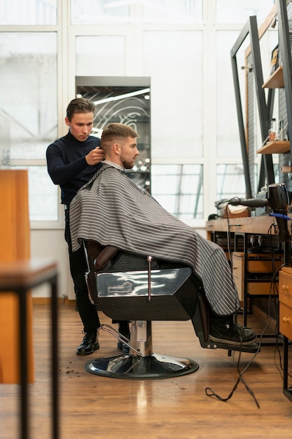 Hombre de tiro completo cortándose el pelo