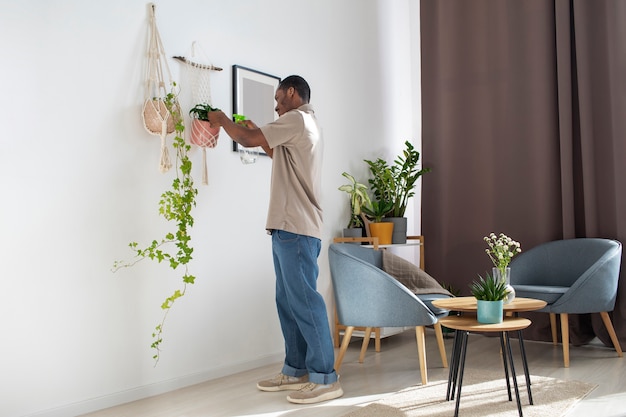 Hombre de tiro completo cuidando plantas.