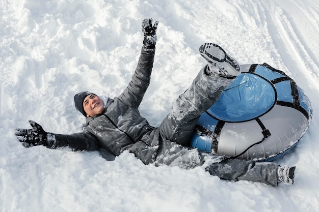 Hombre de tiro completo divirtiéndose en la nieve