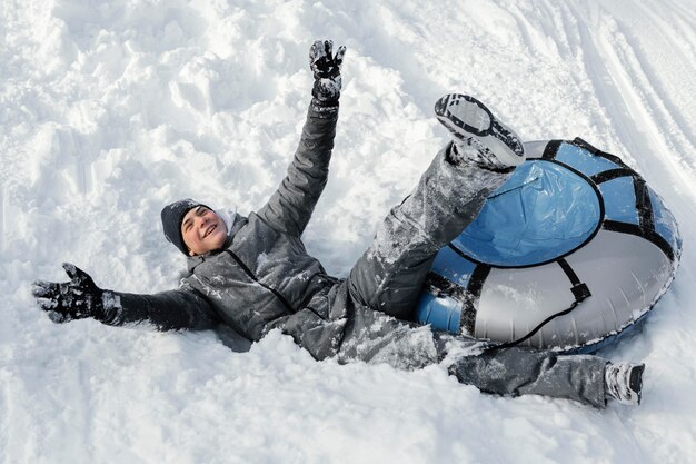 Hombre de tiro completo divirtiéndose en la nieve