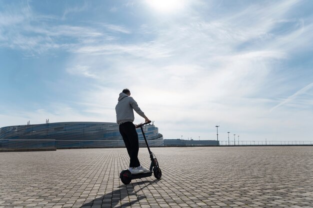 Hombre de tiro completo divirtiéndose con scooter eléctrico