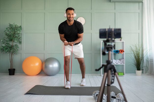 Hombre de tiro completo entrenando con auriculares