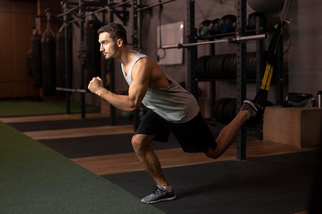 Hombre de tiro completo entrenando en el gimnasio