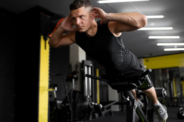 Hombre de tiro completo entrenando en el gimnasio