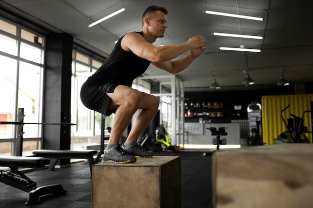 Foto gratuita hombre de tiro completo entrenando en el gimnasio