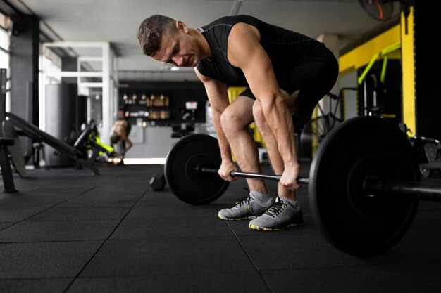 Hombre de tiro completo entrenando con mancuernas