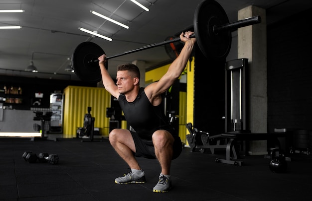 Hombre de tiro completo entrenando con mancuernas