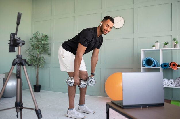 Hombre de tiro completo entrenando con mancuernas