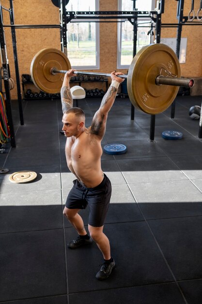 Hombre de tiro completo entrenando con mancuernas