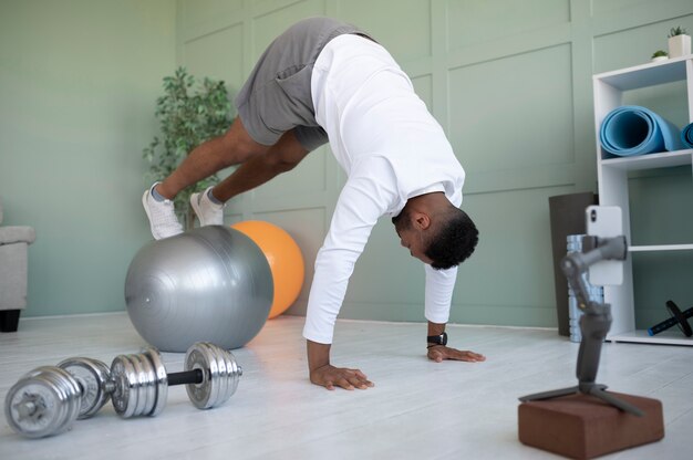 Hombre de tiro completo entrenando con pelota de gimnasia