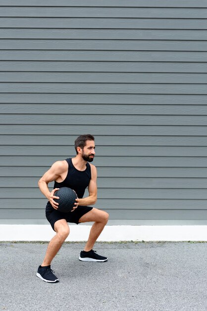 Hombre de tiro completo entrenando con pelota