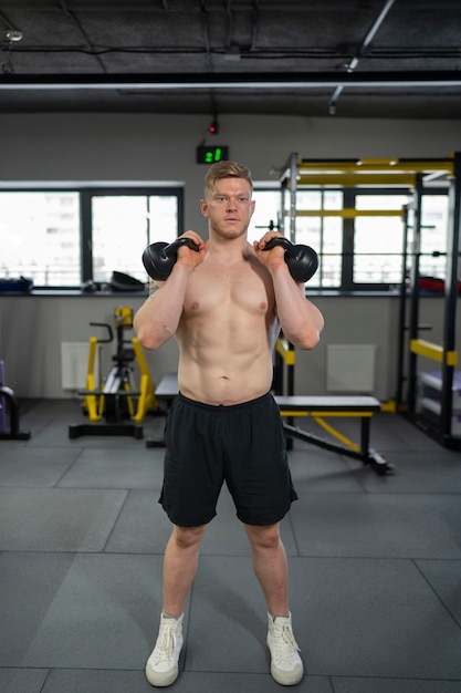 Hombre de tiro completo entrenando con pesas rusas