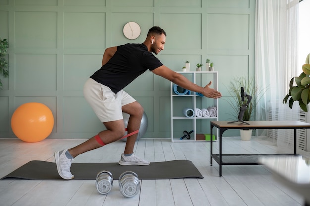 Foto gratuita hombre de tiro completo entrenando con smartphone