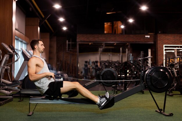 Hombre de tiro completo entrenando en vista lateral del gimnasio