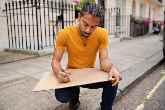 Hombre de tiro completo escribiendo en cartel