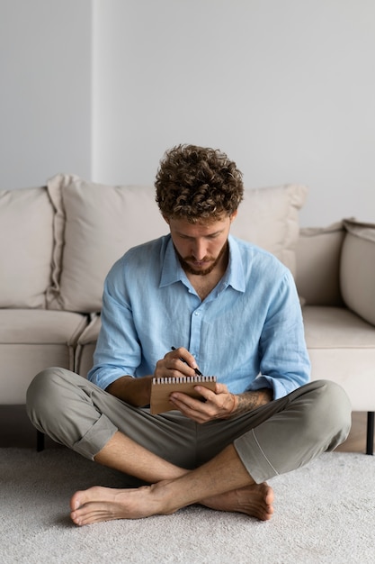 Foto gratuita hombre de tiro completo escribiendo en cuaderno