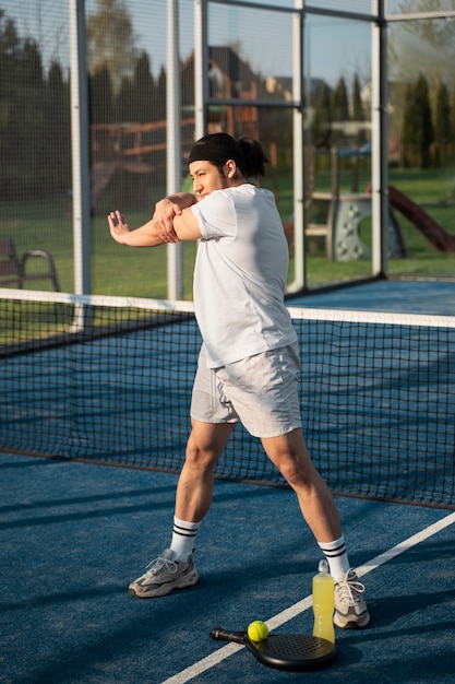 Hombre de tiro completo estirando el brazo