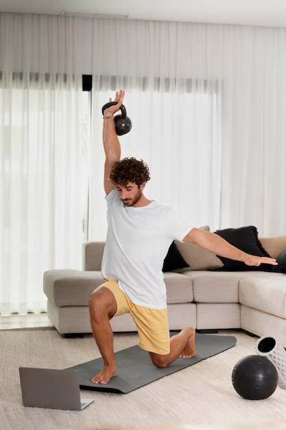 Hombre de tiro completo haciendo deporte en casa