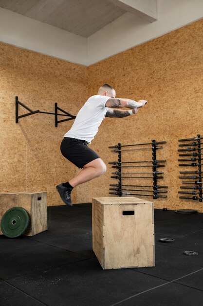 Hombre de tiro completo haciendo ejercicio con caja