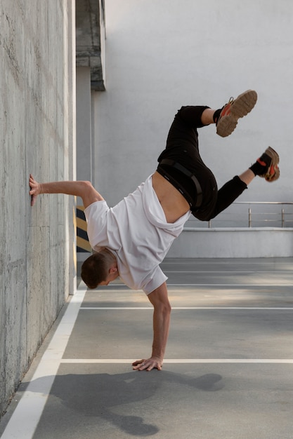 Foto gratuita hombre de tiro completo haciendo entrenamiento de parkour al aire libre