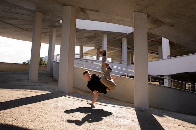 Foto gratuita hombre de tiro completo haciendo entrenamiento de parkour al aire libre