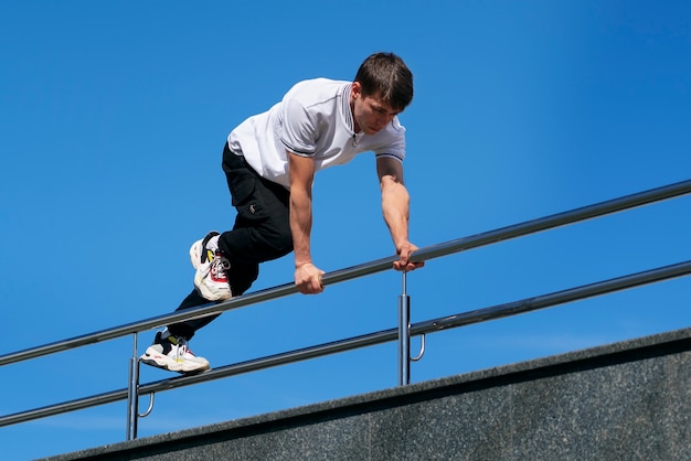 Hombre de tiro completo haciendo entrenamiento de parkour