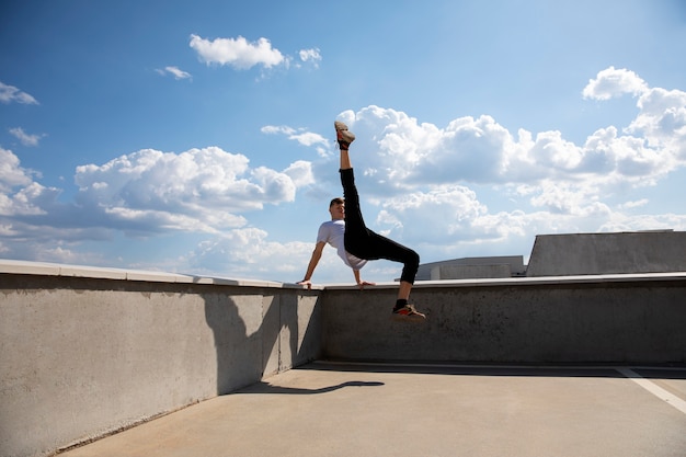 Hombre de tiro completo haciendo entrenamiento de parkour