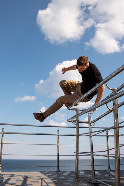 Hombre de tiro completo haciendo entrenamiento de parkour