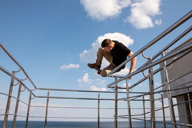 Hombre de tiro completo haciendo entrenamiento de parkour