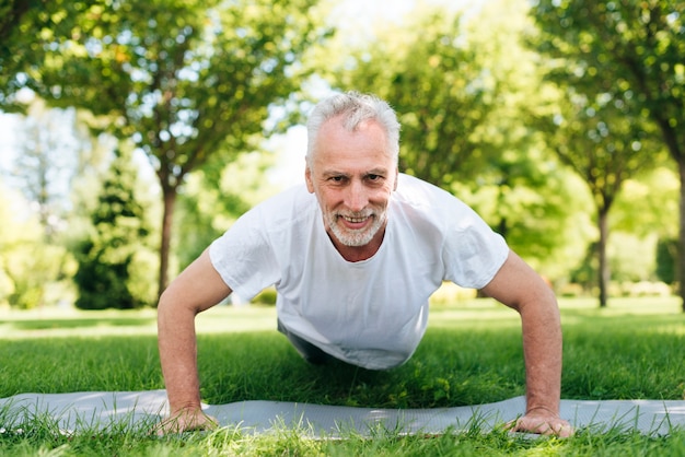 Foto gratuita hombre de tiro completo haciendo flexiones al aire libre