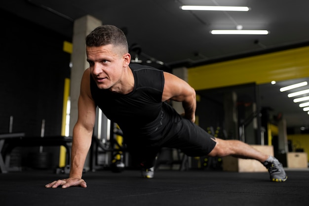 Hombre de tiro completo haciendo flexiones