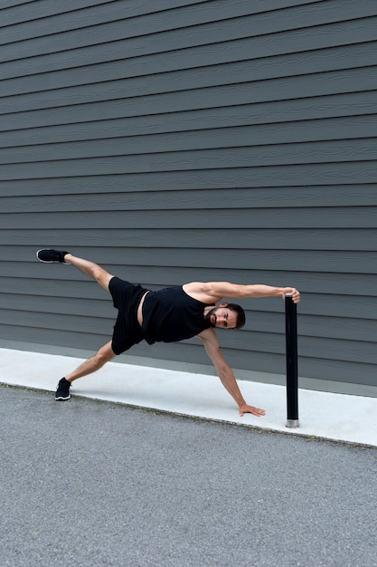 Hombre de tiro completo haciendo plancha lateral