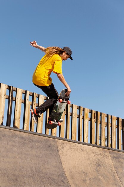 Hombre de tiro completo haciendo trucos en patineta