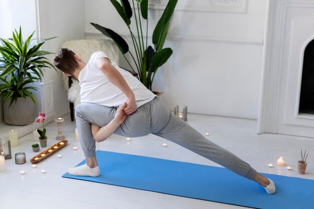 Foto gratuita hombre de tiro completo haciendo yoga en la estera