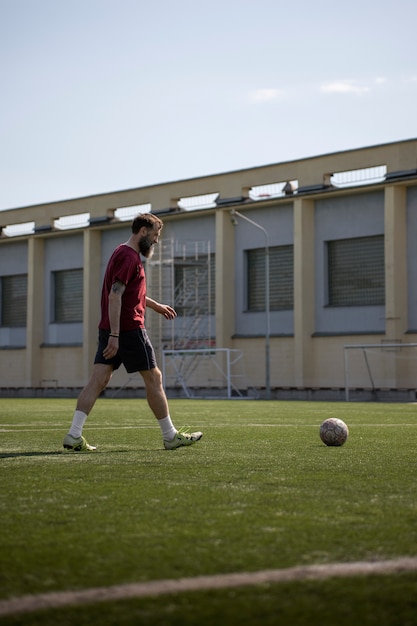 Hombre de tiro completo jugando al fútbol