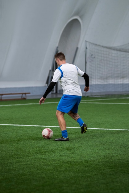 Foto gratuita hombre de tiro completo jugando al fútbol