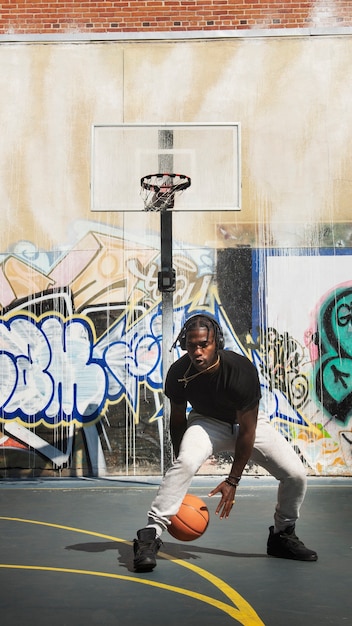 Hombre de tiro completo jugando baloncesto al aire libre