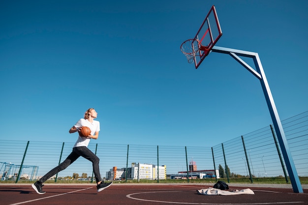 Foto gratuita hombre de tiro completo jugando baloncesto