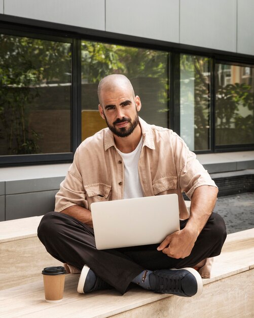 Hombre de tiro completo con laptop