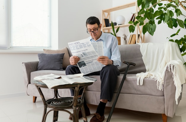 Hombre de tiro completo leyendo el periódico