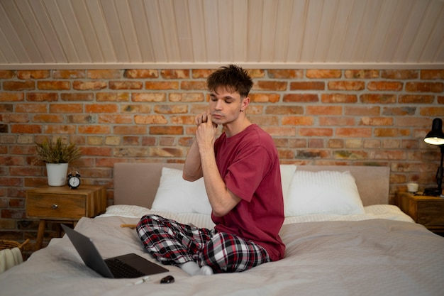 Foto gratuita hombre de tiro completo masajeando la cara en casa